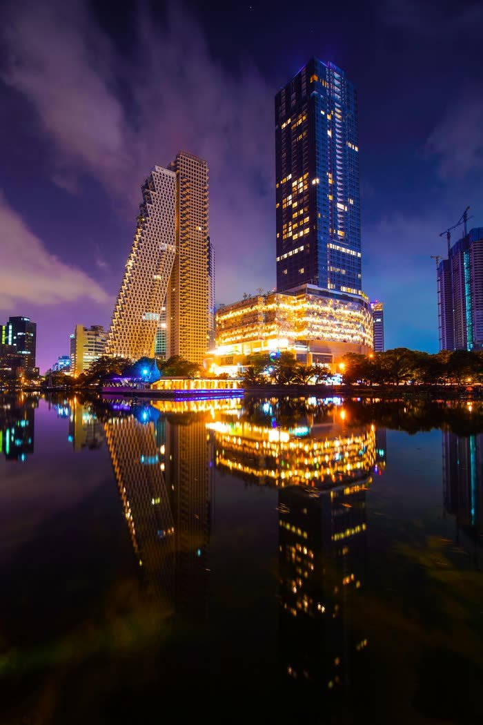 Altair and the Colombo City Centre towers lit at night, reflected in Beira Lake.
